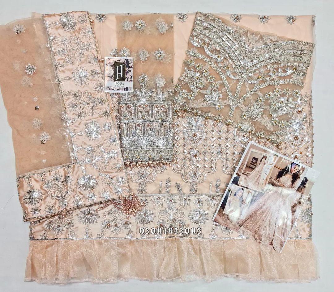 Elegant blush pink bridal lehenga with intricate silver embroidery and sequins.