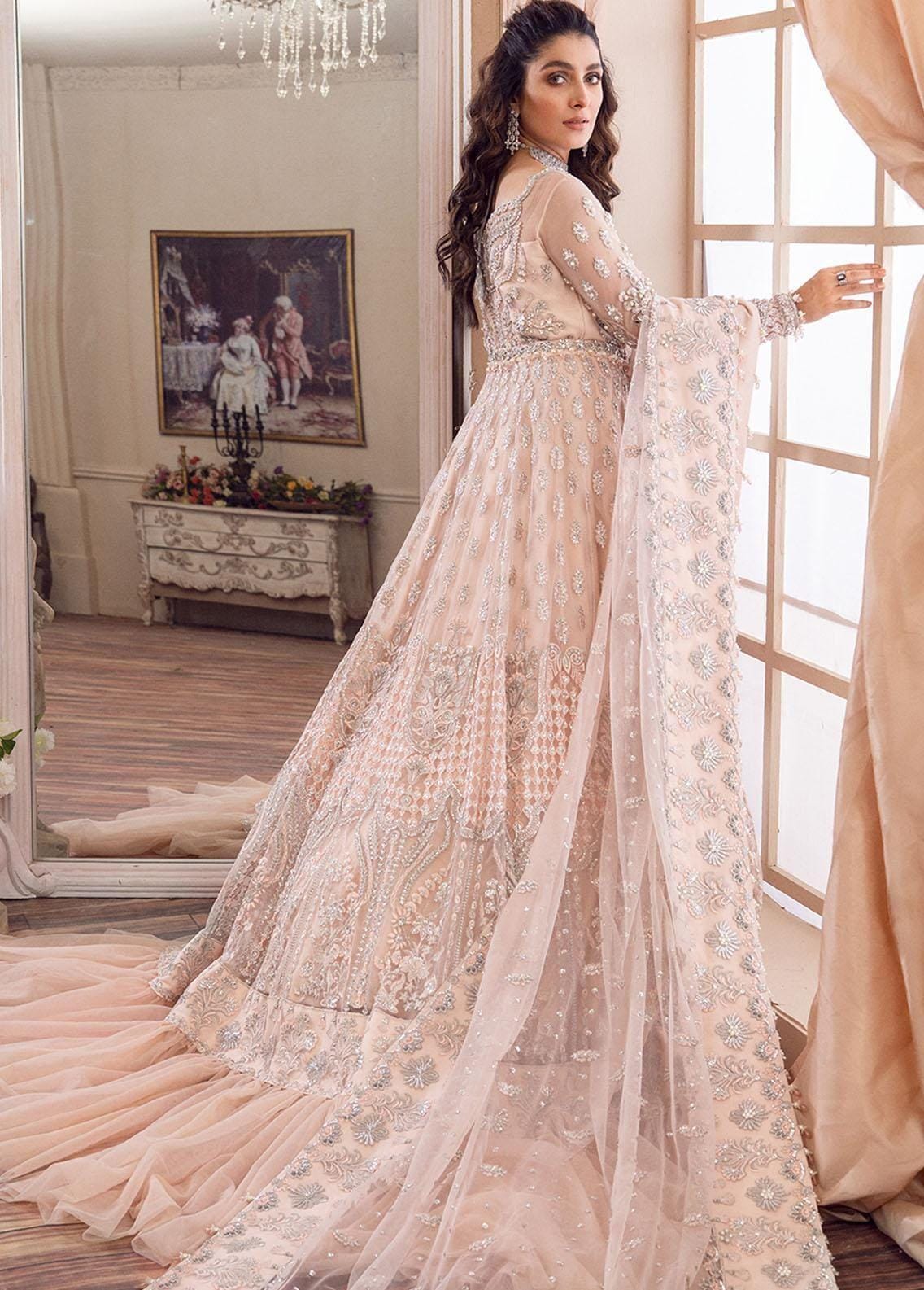 Elegant blush pink bridal lehenga with intricate silver embroidery and sequins.