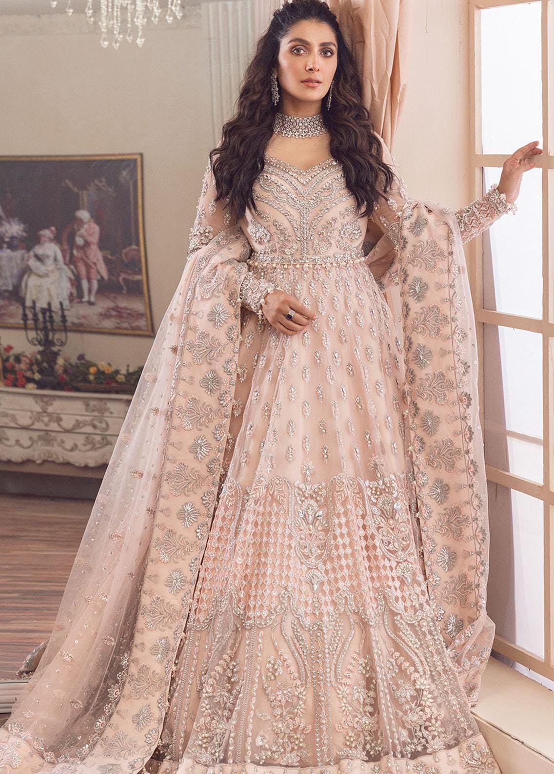 Elegant blush pink bridal lehenga with intricate silver embroidery and sequins.