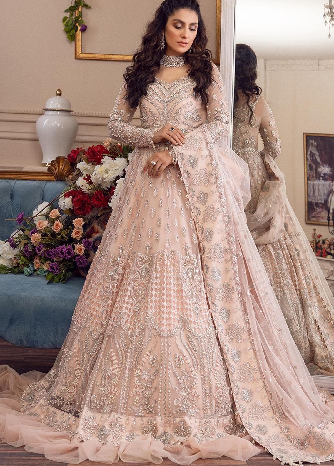 Elegant blush pink bridal lehenga with intricate silver embroidery and sequins.